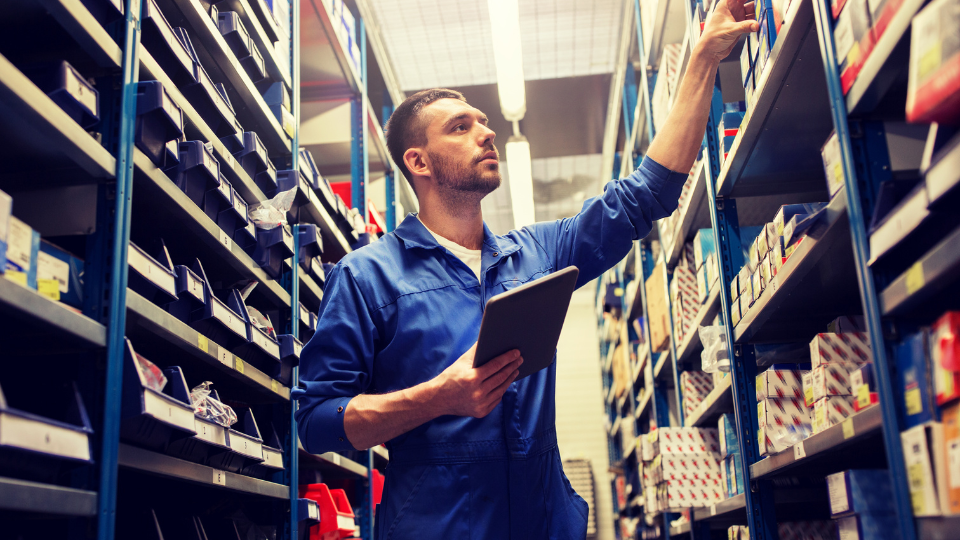 man in a stockroom holding tablet